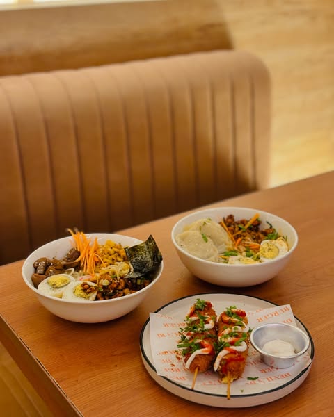 a shot of a table with three plates of food in an anime themed restaurant